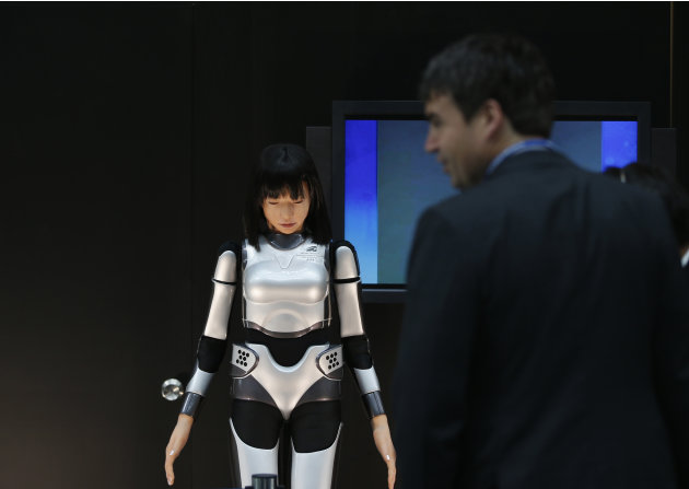Man looks at the HRP-4C Miim humanoid robot at the venue of the Annual Meetings of the International Monetary Fund and the World Bank Group in Tokyo