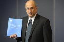 Lord Justice Brian Leveson poses with an executive summary of his report following an inquiry into media practices in central London