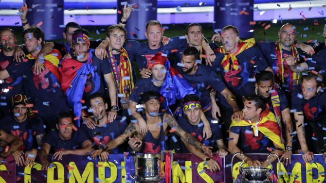 Barcelona players celebrate at the Camp Nou stadium in Barcelona, Spain Sunday June 7, 2015 after winning the Champions League final soccer match Saturday by beating Juventus Turin 3-1. Barcelona won the triple this season winning the Spanish League title, the Copa del Rey and the Champions League. (AP Photo/Emilio Morenatti)