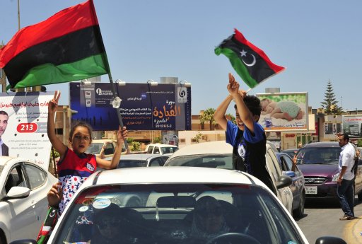 Libyan children wave the Kingdom of Libya flags from a car during the National Assembly election in Benghazi