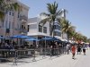 Visitors walk along Ocean Drive, next to barricades placed to separate diners from pedestrians, during the Urban Beach Weekend, on southern Miami Beach