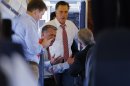 Republican presidential nominee Mitt Romney talks to advisors Garrett Jackson, Bob White and Stuart Stevens on his campaign plane at the airport in Denver