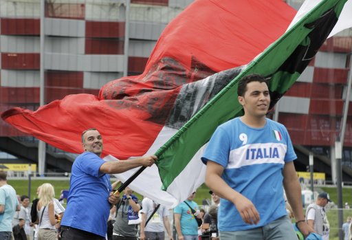 Italy soccer fans wave a giant Italian flag in front of the National stadium in Warsaw