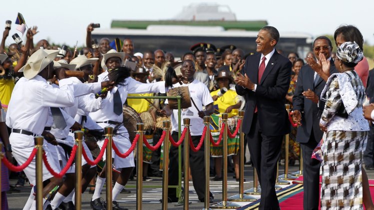U.S. President Barack Obama applauds a group of dancers and musicians during an official arrival ceremony at Julius Nyerere Airport in Dar es Salaam