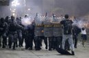 A demonstrator tries to stop the riot police during one of many protests around Brazil's major cities in Rio de Janeiro