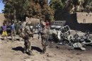 Soldati francesi vicino ai resti di un pickup usato dai ribelli islamici a Diabaly, Mali