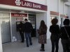 People queue to use an ATM machine outside of a Laiki Bank branch in Larnaca, Cyprus, Saturday, March 16, 2013. Many rushed to cooperative banks which are open Saturdays in Cyprus after learning that the terms of a bailout deal that the cash-strapped country hammered out with international lenders includes a one-time levy on bank deposits. The move, decided in an extraordinary meeting of the finance ministers of the 17-nation eurozone in the early hours Saturday, is a major departure from established policies. Analysts have warned that making depositors take a hit threatens to undermine investors' confidence in other weaker eurozone economies and might possibly lead to bank runs. (AP Photo/Petros Karadjias)