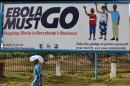 A man walks past an Ebola campaign banner in Monrovia on February 23, 2015