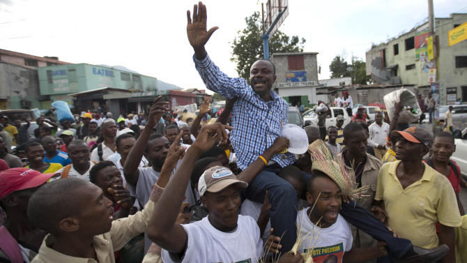 In this Oct. 17, 2015 photo, presidential candidate Moise Jean Charles, of the Platform Pitit Dessalines political party, is carried by supporters as he campaigns in Port-au-Prince, Haiti. This year’s unprecedented three rounds of balloting will pick Haiti’s next president, two-thirds of the Senate, the entire Chamber of Deputies and local offices. The Oct. 25 vote is expected to clear the sprawling presidential field for a runoff Dec. 27 between the top two finishers. (AP Photo/Dieu Nalio Chery)