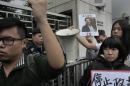 A protester holds a photo of missing bookseller Lee Bo during a protest outside the Liaison of the Central People's Government in Hong Kong, Sunday, Jan. 3, 2016. Hong Kong pro-democracy lawmakers say they'll press the government for answers after a fifth employee of a publisher specializing in books critical of China's ruling communists went missing. (AP Photo/Vincent Yu)
