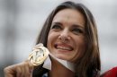 Russia's Yelena Isinbayeva poses with her gold medal in the women's pole vault as she stands on the podium during the medal ceremony at the World Athletics Championships in the Luzhniki stadium in Moscow, Russia, Thursday, Aug. 15, 2013. (AP Photo/Alexander Zemlianichenko)