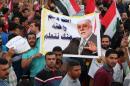 Iraqi demonstrators hold a banner bearing a portrait of Prime Minister Haider al-Abadi during a demonstration to express support for his reform drive while calling on him to do more on August 14, 2015 in Baghdad's Tahrir Square