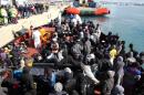 Migrants wait to disembark from a tug boat after being rescued in the Pozzallo harbor, Sicily, Italy, Sunday, Feb. 15, 2015. An Italian government official says four smugglers brandishing Kalashnikovs threatened an Italian Coast Guard motorboat that had just rescued migrants off the coast of Libya, where the security is rapidly deteriorating. Transport Minister Maurizio Lupi said the gunmen had sped to the scene Sunday afternoon aboard a small boat some 50 miles (80 kilometers) off Libyan shores. After threatening the Coast Guard rescuers who had taken aboard the migrants, three of the smugglers jumped aboard the then-empty migrants' boat to reclaim it and took off. In all, nearly 2,200 migrants were rescued in several operations Sunday, the Coast Guard said. They were being taken to Italian ports. (AP Photo/Francesco Malavolta)