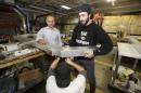 In a photo from Thursday, Oct. 8, 2015, in Warren, Mich., business owner Ismael Basha, left, looks on as Syrian refugee Mohammed Abo-Shaar, right, helps a co-worker assemble a frame. Basha, who came from Syria in the early 1980s, owns TSS Inc., which has 50 workers and makes automatic car wash fixtures and systems. Over the years, he said, he he's hired refugees from Bosnia-Herzegovina, Serbia and Iraq, and, in recent weeks, several from Syria. He said they typically work hard and are dedicated. Many more are expected since the Obama administration pledged to accept about 10,000 Syrians in the next 12 months. (AP Photo/Carlos Osorio)