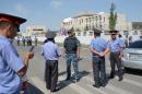 Kyrgyz police officers gather outside the Chinese embassy in Bishkek on August 30, 2016 following a suicide bombing