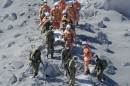 JSDF soldiers and firefighters carry an injured person near a crater of Mt. Ontake, which straddles Nagano and Gifu prefecture