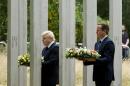 Britain's Prime Minister David Cameron, right, and London Mayor Boris Johnson walk through the 7/7 memorial in Hyde Park to lay wreaths in London, Tuesday, July 7, 2015. Britons marked the 10th anniversary of suicide bomb attacks on London's transit system Tuesday, as Prime Minister David Cameron said the recent slaying of 30 British tourists in Tunisia was a reminder that terror threats remain real and deadly. (AP Photo/Matt Dunham)