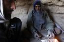 Drug addict smokes heroin inside a cave in Farah province