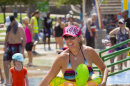 Kim Roer smiles as she cools off at the splash pad at Tempe Beach Park during the Tempe Bicycle Action Group swimsuit ride in Tempe, Ariz. on Saturday, June 29, 2013. About 100 biked around the city cooling off in splash pads, pools and fountains. (AP Photo/The Arizona Republic, David Wallace)