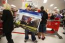 Thanksgiving Day holiday shopper carries a discounted television to the checkout at the Target retail store in Chicago