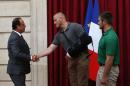 French President Francois Hollande, left, shakes hands with U.S. Airman Spencer Stone, as U.S. National Guardsman from Roseburg, Oregon, Alek Skarlatos, right, looks on at the Elysee Palace, Monday Aug.24, 2015 in Paris, France. Three Americans and a British man who took down a heavily armed man on a passenger train speeding through Belgium have received France's top honor.(AP Photo/Michel Euler, Pool)
