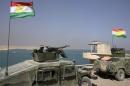 Peshmerga fighters are seen in vehicles with Kurdish flags as they guard Mosul Dam in northern Iraq