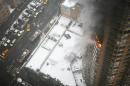 Flames and smoke emerge from the 20th floor of the Strand apartment building near Times Square, Sunday, Jan. 5, 2014 in New York. Authorities say two people have been critically injured in the three-alarm high-rise fire. (AP Photo/Katherine Bourbeau)