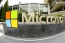 This photo taken with a fisheye lens on July 3, 2014 shows Microsoft Corp. signage outside the Microsoft Visitor Center in Redmond, Wash. Microsoft on Thursday, July 17, 2014 announced it will lay off up to 18,000 workers over the next year. (AP Photo Ted S. Warren)