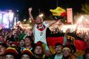 German fans react as they watch a live broadcast of the final match between Germany and Argentina at the soccer World Cup 2014 in Rio de Janeiro, Brazil, at a public viewing area called 'Fan Mile' in Berlin, Sunday, July 13, 2014. (AP Photo/Markus Schreiber)