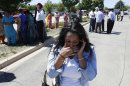 A woman reacts with others as they await word on a shooting at a Sikh temple in Oak Creek, Wis., Sunday, Aug. 5, 2012, where police and witnesses describe a chaotic situation with an unknown number of victims, suspects and possible hostages. (AP Photo/Jeffrey Phelps)