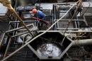 The flow of drilling mud is seen in a container while an oilfield worker works on a drilling rig at an oil well operated by Venezuela's state oil company PDVSA, in the oil rich Orinoco belt, near Cabrutica at the state of Anzoategui
