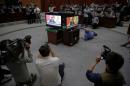 Foreign reporters gather around screens broadcasting address by North Korean leader Kim Jong Un to the Workers' Party of Korea (WPK) congress, at a hotel in central Pyongyang