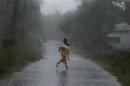 A girl runs for shelter in heavy rain brought by Cyclone Phailin in Ichapuram