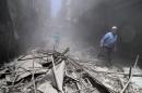 Syrians walk through the rubble following a reported air strike by Syrian government forces in the rebel-held neighbourhood of Bustan al-Qasr