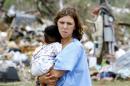 Kayla Holcey, right, holds her 8-month-old son Kristian Hampton as she looks at the debris that was once her home, Tuesday, April 29, 2014, in Crawford, Ala. Holcy said that she was terrified that her son had been killed until she heard his cries under the rubble. A tornado tore through the Crawford community before dawn. (AP Photo/The Ledger-Enquirer, Robin Trimarchi) MANDATORY CREDIT