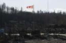 A Canadian flag flies over damage caused by a wildfire in Fort McMurray