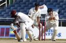 New Zealand's wicket keeper BJ Watling, right, shouts as Ross Taylor, center, looks on after attempting to stump West Indies Kemar Roach, left, during the second innings on the fourth day of their first cricket Test match in Kingston, Jamaica, Wednesday, June 11, 2014. (AP Photo/Arnulfo Franco)
