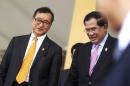 Cambodia's Prime Minister Hun Sen (R) and Sam Rainsy, president of the Cambodia National Rescue Party (CNRP), smile after a plenary session at the National Assembly in Phnom Penh