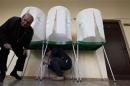Electoral officials tape voting booths at a polling station in Tbilisi