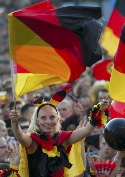 Germany supporter waves flags during public screening of Germany vs Portugal Euro 2012 soccer match in Berlin