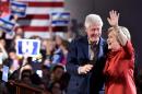 Democratic presidential candidate Hillary Clinton (R) and husband Bill Clinton (L) wave to a cheering crowd after winning the Nevada democratic caucus at Caesar's Palace in Las Vegas, Nevada on February 20, 2016
