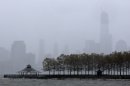 One World Trade Center, right, peeks through a light rain as water from the Hudson River creeps up on Pier A Park with the expected arrival of Hurricane Sandy in Hoboken, N.J., Monday, Oct. 29, 2012. Hurricane Sandy continued on its path Monday, as the storm forced the shutdown of mass transit, schools and financial markets, sending coastal residents fleeing, and threatening a dangerous mix of high winds and soaking rain. (AP Photo/Julio Cortez)