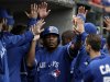 Toronto Blue Jays' Edwin Encarnacion, center, celebrates after scoring on a Mark DeRosa two-run double against the Detroit Tigers in the sixth inning of a baseball game in Detroit, Wednesday, April 10, 2013. (AP Photo/Paul Sancya)