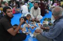 Supporters of deposed Egyptian President Mohamed Mursi break their fast during first day of Ramadan outside Rabaa Adawiya mosque in Cairo