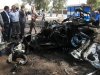 People and security forces inspect the scene of a car bomb attack in Kirkuk, 290 kilometers (180 miles) north of Baghdad, Iraq, Thursday, Aug 16, 2012.  Five separate bombings in central and northern Iraq, killed and wounded scores of people early Thursday, police said. (AP Photo/Emad Matti)