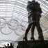 A couple pauses at the foot of a statue with the Olympic rings hung in the rafters of St. Pancras Station prior to the 2012 Summer Olympics, Tuesday, July 24, 2012, in London. The opening ceremonies for the 2012 London Olympics will be held Friday, July 27. (AP Photo/Charles Krupa)