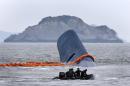 Vessel involved in salvage operations passes near the upturned South Korean ferry "Sewol" in the sea off Jindo
