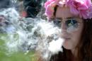 A woman smokes marijuana during the 4/20 Rally at the Civic Center in Denver