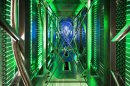 In this undated photo made available by Google, hundreds of fans funnel hot air from the computer servers into a cooling unit to be recirculated at a Google data center in Mayes County. Okla. The green lights are the server status LEDs reflecting from the front of the servers. (AP Photo/Google, Connie Zhou)