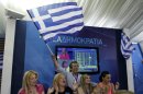 Supporters of the New Democracy conservative party celebrate at an election kiosk at Syntagma square in Athens, Sunday, June 17, 2012. The pro-bailout New Democracy party came in first Sunday in Greece's national election, and its leader has proposed forming a pro-euro coalition government.(AP Photo/Kostas Tsironis)